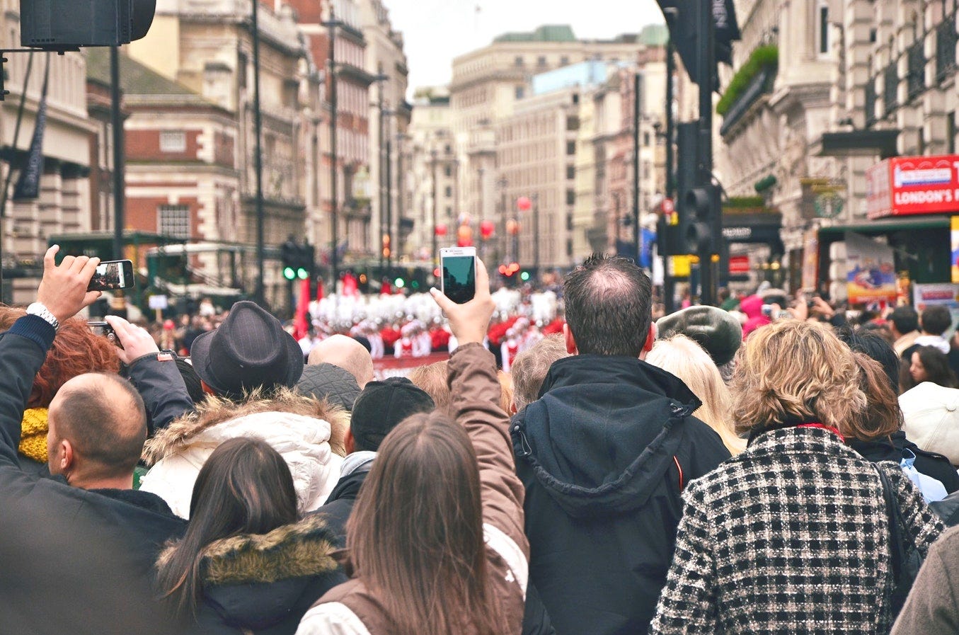 Piccadilly Circus packed with people taking photos.